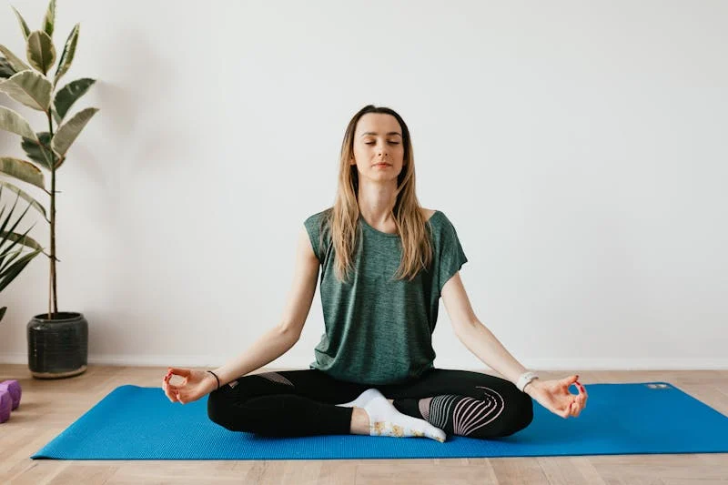 Un grupo de personas practica yoga en un estudio iluminado por el sol.